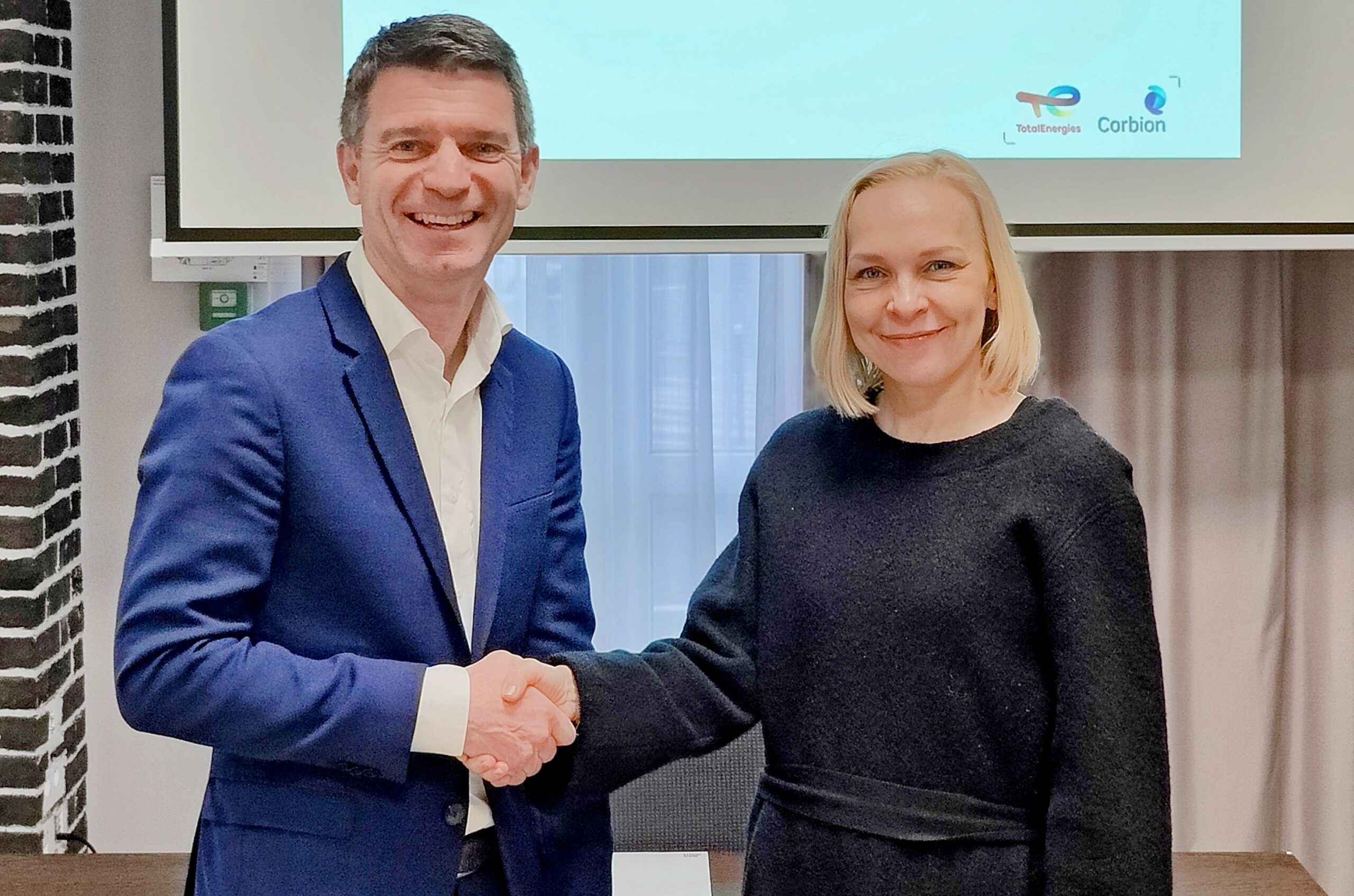 Two CEOs shake hands smiling