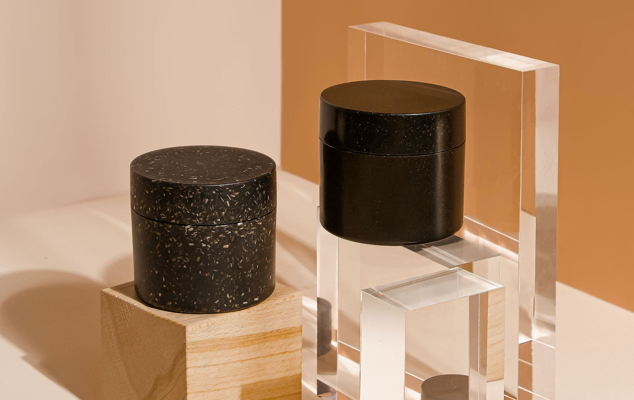 Packaging with a glossy, smooth surface, and a a similar jar with a vivid surface with natural look, both made with Sulapac